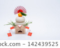 A photo of a real rice cake, "Kagami-mochi," placed on the left, on a white background, with a low sanpo (pedestal) 142439525