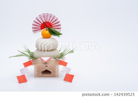 A photo of a real rice cake, "Kagami-mochi," placed on the left, on a white background, with a low sanpo (pedestal) A photo of a real rice cake, "Kagami-mochi," placed on the left, on a white background, with a low sanpo (pedestal) 142439525