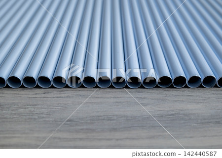 Row of light blue PVC pipes on concrete surface Row of light blue PVC pipes on concrete surface 142440587