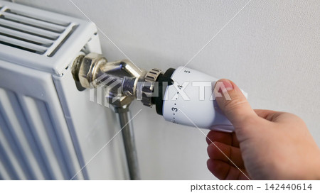 Hand Adjusting Heating Radiator Valve in Home Hand Adjusting Heating Radiator Valve in Home 142440614