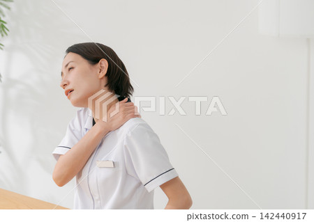 一位在美容院工作的女性,患有肩部僵硬症。 一位在美容院工作的女性,患有肩部僵硬症。 142440917