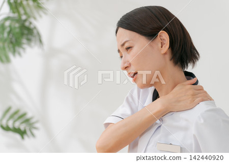 A woman working at a beauty salon who suffers from stiff shoulders A woman working at a beauty salon who suffers from stiff shoulders 142440920