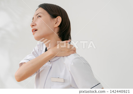 A woman working at a beauty salon who suffers from stiff shoulders A woman working at a beauty salon who suffers from stiff shoulders 142440921