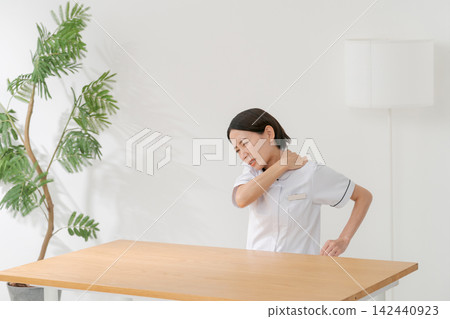 A woman working at a beauty salon who suffers from stiff shoulders A woman working at a beauty salon who suffers from stiff shoulders 142440923