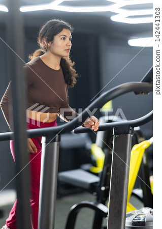 Latina woman exercising on treadmill Latina woman exercising on treadmill 142441308