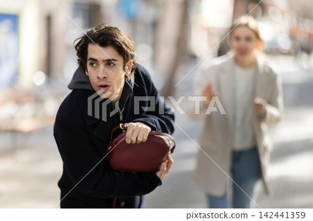 Thief steals girls handbag and runs away with stolen property Thief steals girls handbag and runs away with stolen property 142441359