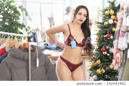 Girl try on lingerie in front of mirror in clothes store, X mas Eve Girl try on lingerie in front of mirror in clothes store, X mas Eve 142441401