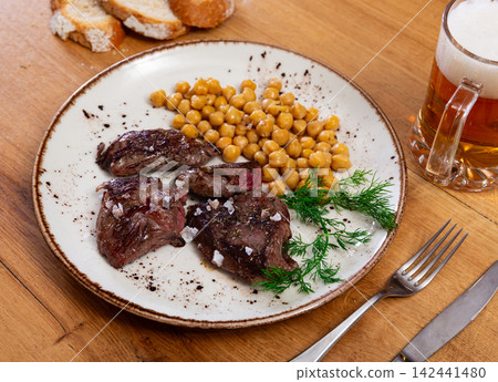Stewed or fried beef tenderloin is served with chickpea ragout Stewed or fried beef tenderloin is served with chickpea ragout 142441480