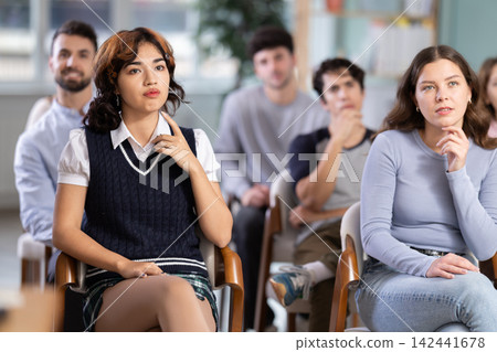 Group of young students listening during seminar in a modern classroom Group of young students listening during seminar in a modern classroom 142441678