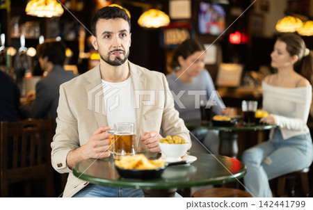 Man sitting in bar and watching game 142441799