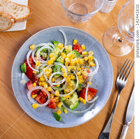 Delicious vegetable salad with avocado, tomatoes and onions on a plate Delicious vegetable salad with avocado, tomatoes and onions on a plate 142441810