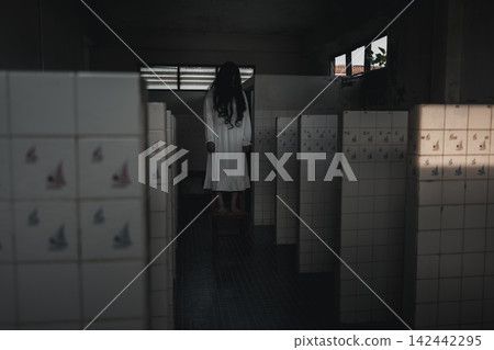 Halloween theme featuring scary woman standing inside dark abandoned restroom wearing white dress, creating eerie horror atmosphere for holiday celebration and spooky seasonal event 142442295