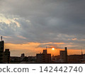 Watching the sunset being chased by rain clouds from a pedestrian overpass. 142442740