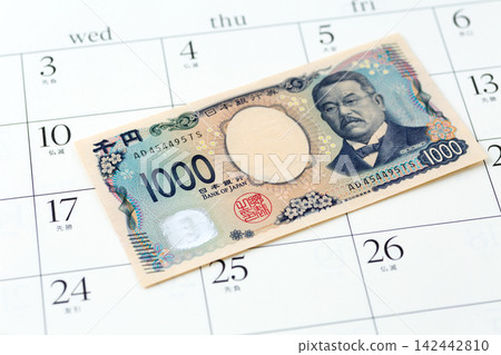 A thousand-yen bill and a calendar A thousand-yen bill and a calendar 142442810