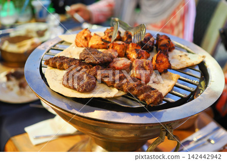 Mixed Kebab Grill With Chicken and Beef Skewers on Flatbread Served Hot From Charcoal Grill 142442942