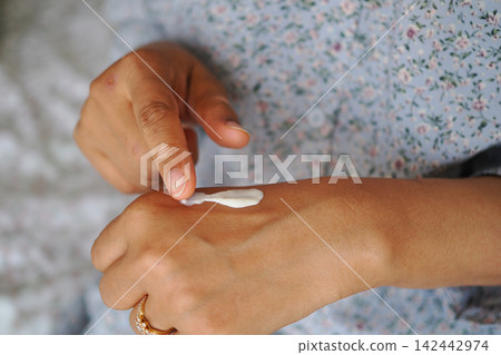 Applying cream to the hand at home in the morning Applying cream to the hand at home in the morning 142442974