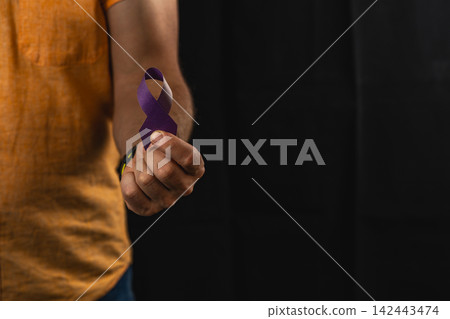 Support campaign for health awareness with a purple ribbon in hand Support campaign for health awareness with a purple ribbon in hand 142443474