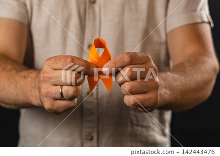 Man holding an orange ribbon to show support for a health campaign 142443476