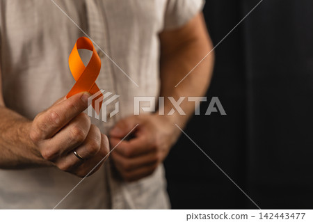 Support for health awareness with orange ribbon in studio setting Support for health awareness with orange ribbon in studio setting 142443477