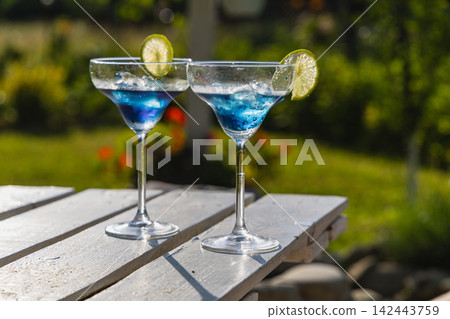 Refreshing blue cocktails served in a garden during summer celebrations Refreshing blue cocktails served in a garden during summer celebrations 142443759