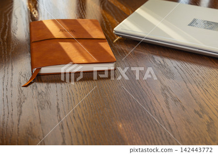Workspace with laptop and notebook on wooden desk for planning tasks Workspace with laptop and notebook on wooden desk for planning tasks 142443772