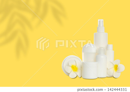 Cosmetics. Cosmetics laid out with toilet bag and delicate flowers on bright background Cosmetics. Cosmetics laid out with toilet bag and delicate flowers on bright background 142444331