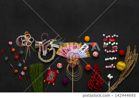 在黑色背景上,色彩鮮豔的傳統日本新年裝飾和吉祥物格外引人注目。 在黑色背景上,色彩鮮豔的傳統日本新年裝飾和吉祥物格外引人注目。 142444693