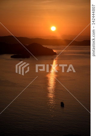 Keindahan matahari terbit di pulau Padar di Manggarai Barat, Flores, Indonesia dengan sinar matahari berwarna kuning kemerahan 142444807