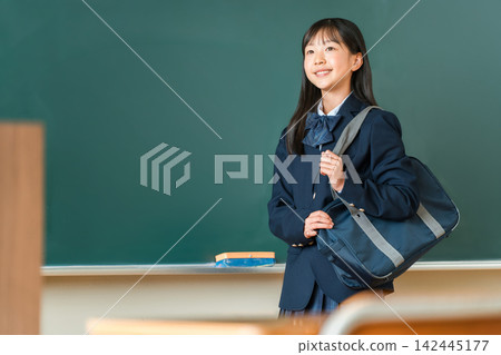 High school and junior high school girls smiling in the classroom with their school bags. High school and junior high school girls smiling in the classroom with their school bags. 142445177