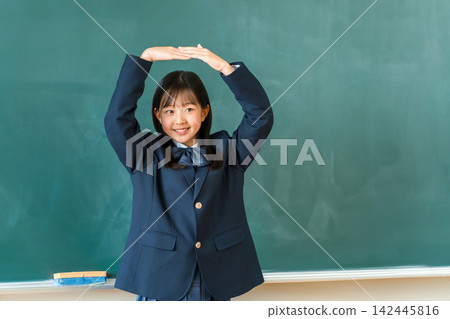 國中和高中女生身穿校服，在教室黑板前圍成一個圓圈。 142445816