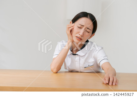 一位女士在美容院裡,表情沮喪。 一位女士在美容院裡,表情沮喪。 142445927