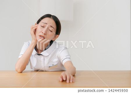 一位女士在美容院裡,表情沮喪。 一位女士在美容院裡,表情沮喪。 142445930