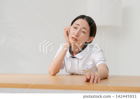 一位女士在美容院裡,表情沮喪。 一位女士在美容院裡,表情沮喪。 142445931