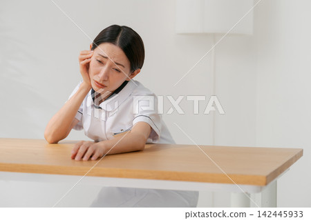 一位女士在美容院裡,表情沮喪。 一位女士在美容院裡,表情沮喪。 142445933