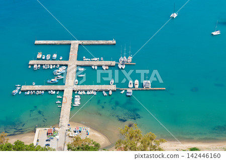 Aerial view of a modern geometric pier filled with yachts and boats in clear blue water Aerial view of a modern geometric pier filled with yachts and boats in clear blue water 142446160
