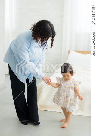 A mother holding the hand of her one-year-old daughter. A mother holding the hand of her one-year-old daughter. 142447497