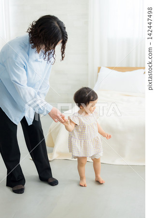 A mother holding the hand of her one-year-old daughter. A mother holding the hand of her one-year-old daughter. 142447498
