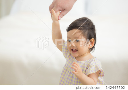 A mother holding the hand of her one-year-old daughter. A mother holding the hand of her one-year-old daughter. 142447502