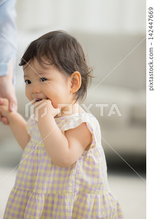 A 1-year-old girl and her mother in the living room A 1-year-old girl and her mother in the living room 142447669