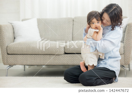 A 1-year-old girl and her mother in the living room A 1-year-old girl and her mother in the living room 142447672
