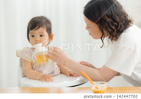 一個一歲女嬰在吃嬰兒食品 一個一歲女嬰在吃嬰兒食品 142447702