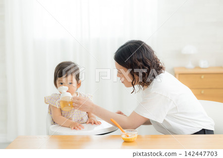 一個一歲女嬰在吃嬰兒食品 一個一歲女嬰在吃嬰兒食品 142447703