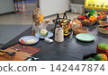 Little girl playing at an improvised kitchen with numerous toy ingredients and dishes preparing a meal from toy cabbage. Pretend cooking concept 142447874