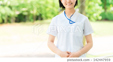 年輕的女性醫護人員，身穿白色polo衫，微笑著。 142447959