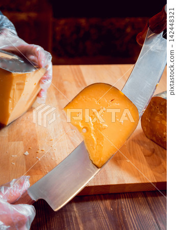 Cut with a knife piece of cheese Cut with a knife piece of cheese 142448321
