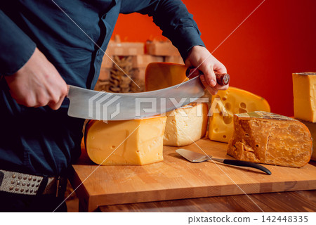 Cut with a knife piece of cheese Cut with a knife piece of cheese 142448335