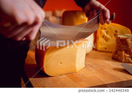 Cut with a knife piece of cheese Cut with a knife piece of cheese 142448340