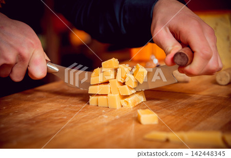Cut with a knife piece of cheese Cut with a knife piece of cheese 142448345