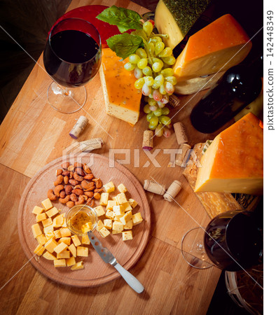 Cheese and wine on a dark table. 142448349