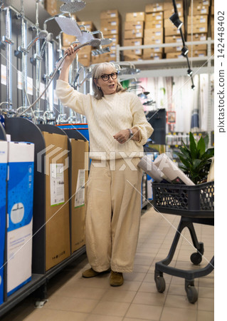 Senior woman shopping for bathroom fixtures in a hardware store Senior woman shopping for bathroom fixtures in a hardware store 142448402